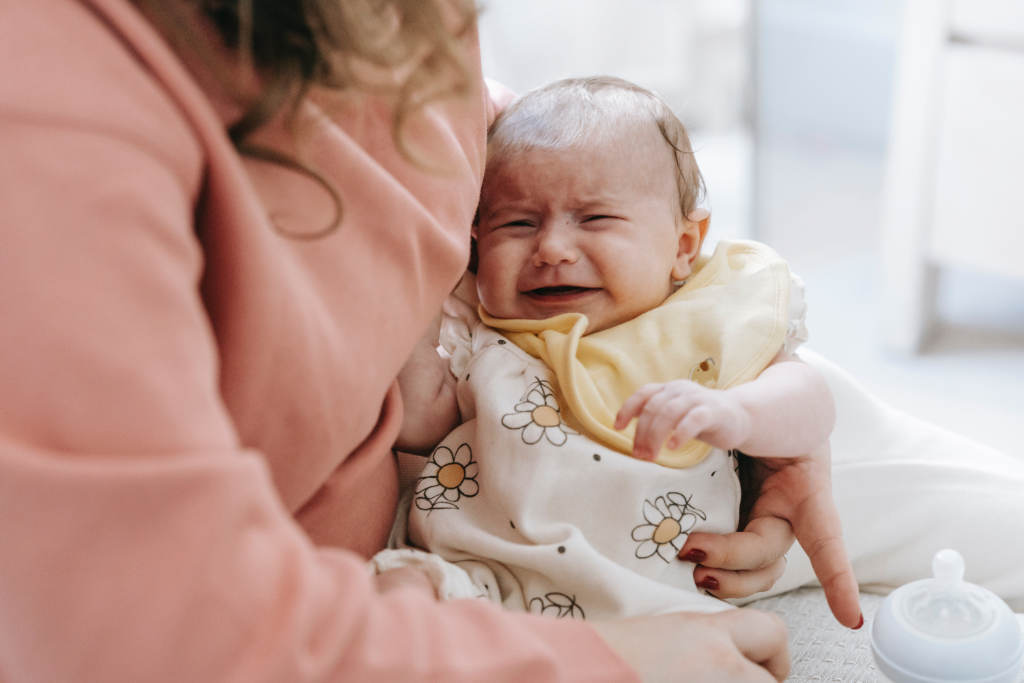 crying baby with bottle